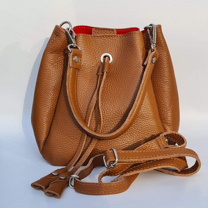 Small bucket bag in tan leather with a handle and a shoulder strap