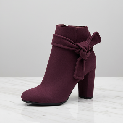 Purple ankle boot with a bow on a light gray background