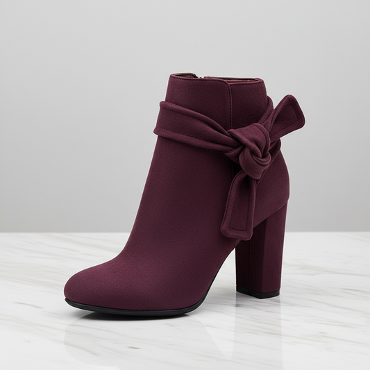 Purple ankle boot with a bow on a light gray background