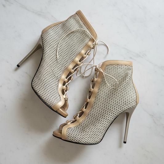 Flatlay of VENUS gold perforated lace-up boots on marble, highlighting perforated leather and platform.