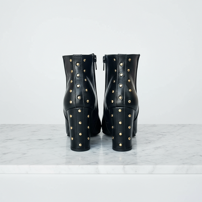 Block heel ankle boots in black leather with gold studs on the heel.